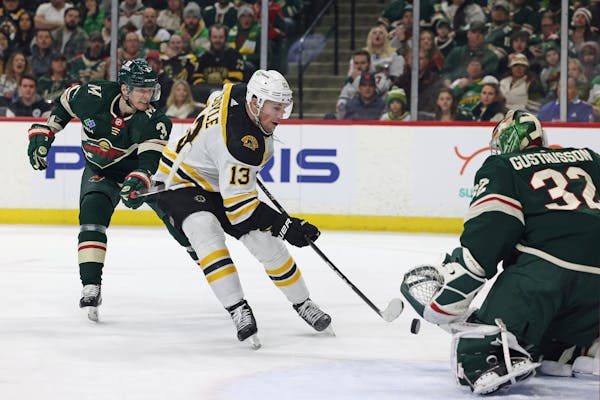 Boston Bruins center Charlie Coyle (13) tries to score a goal against Minnesota Wild goaltender Filip Gustavsson (32) during the second period of an N
