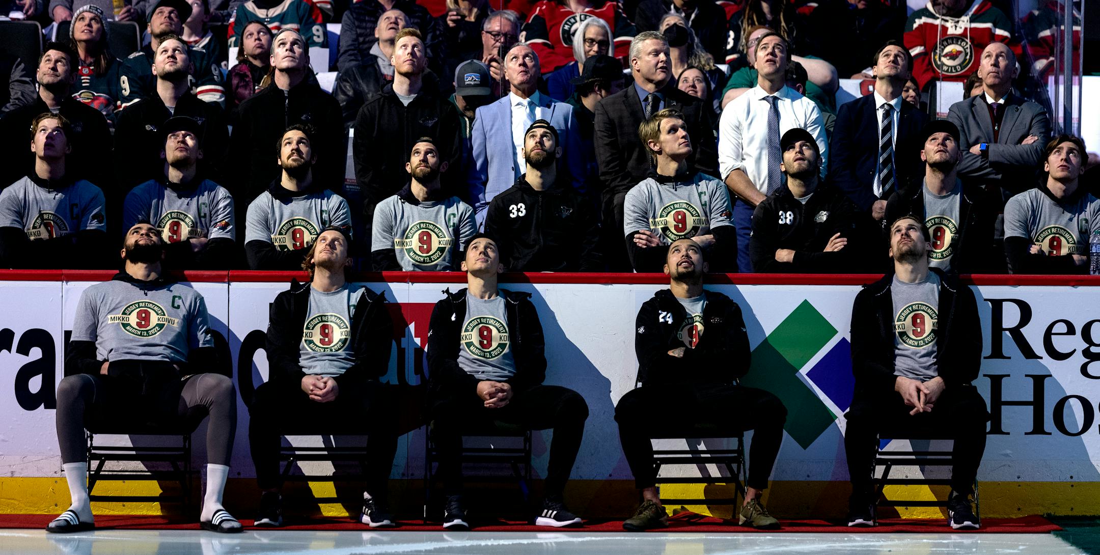 Minnesota Wild players watch a tribute to Mikko Koivu during a ceremony to retire his number.