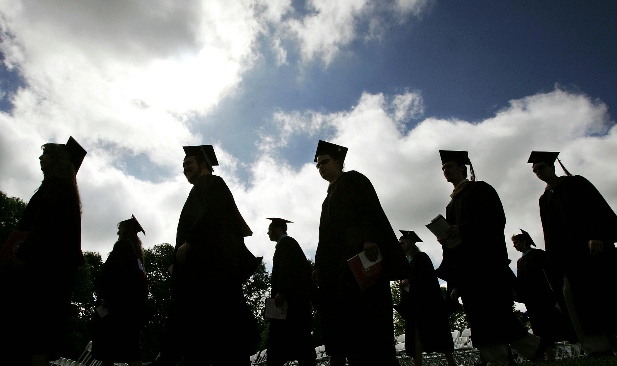 FILE - In this Friday, May 12, 2006, file photo, university students in their caps and gowns are silhouetted as they line up for graduation ceremonies in Lawrenceville, N.J. Students drop out of college for a mix of personal, financial and academic reasons, but there are resources for those who want to finally earn a degree. (AP Photo/Mel Evans, File)