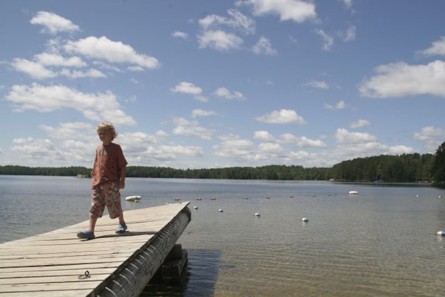 The author's son Henrik checks out the dock at Camp du Nord. Swimming and canoeing are among the offerings at the camp, which is designed to be a simple place where families spend time together.