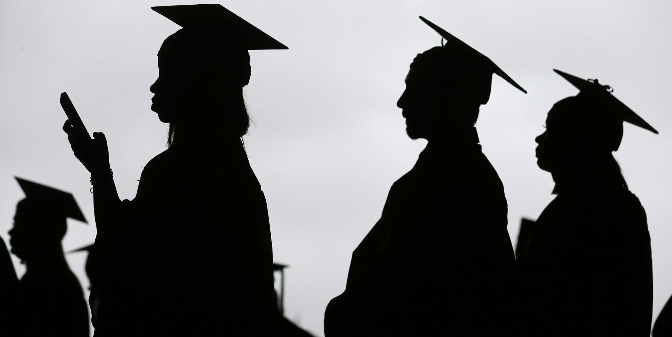 FILE- In this May 17, 2018, file photo, new graduates line up before the start of the Bergen Community College commencement at MetLife Stadium in East Rutherford, N.J. Obtaining a college degree has increasingly coincided with ever-higher student debt loads. Since 2004, total student debt has climbed more than 540 percent to $1.4 trillion, according to the New York Federal Reserve. (AP Photo/Seth Wenig, File)