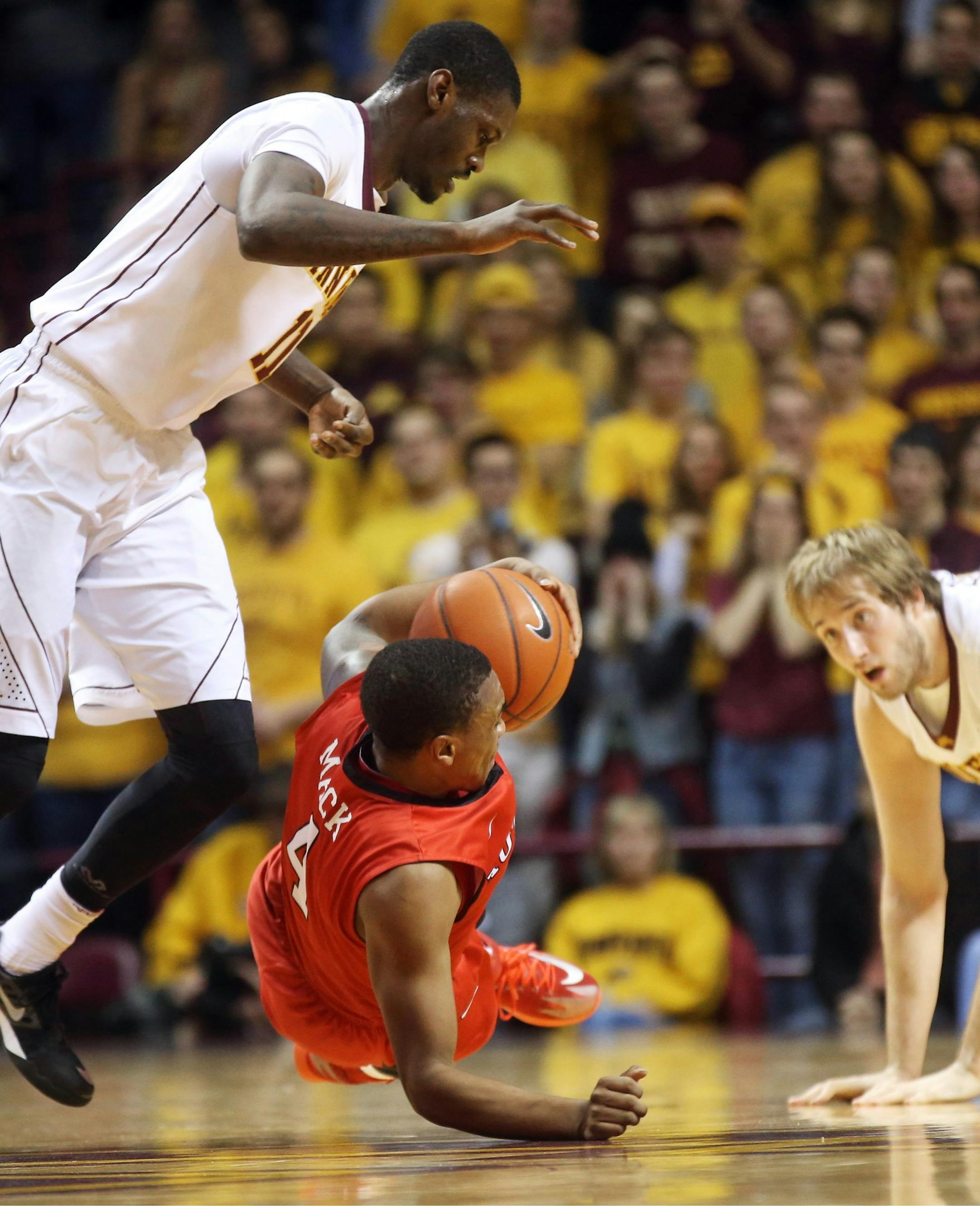 Rutgers&#x2019;s Myles Mack, center, tries to maintain control of the ball as Minnesota&#x2019;s Carlos Morris, left, looms over him after a scramble for the ball with Minnesota&#x2019;s Elliott Eliason, right, in the first half of an NCAA college basketball game, Saturday, Jan. 17, 2015, in Minneapolis. (AP Photo/Jim Mone)
