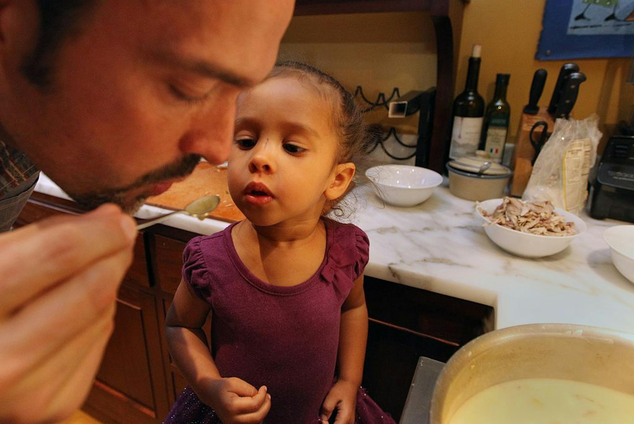 Chef, Alex Roberts with daughter Nia Belle, 2, taste the Creamy chicken broth as they prepared the family meal together. _ Taste cover on chefs with kids cooking for their families. Will include Isaac Becker, who owns Bar La Grassa and 112 Eatery and soon to be completed Burch with wife Nancy, who runs front of restaurant. Plus Alex Roberts of Brasa and Restaurant Alma plus Michelle Gayer of Salty Tart. [ TOM WALLACE • twallace@startribune.com _ Assignments #20025406A_sept 18, 2012_ SLUG: family