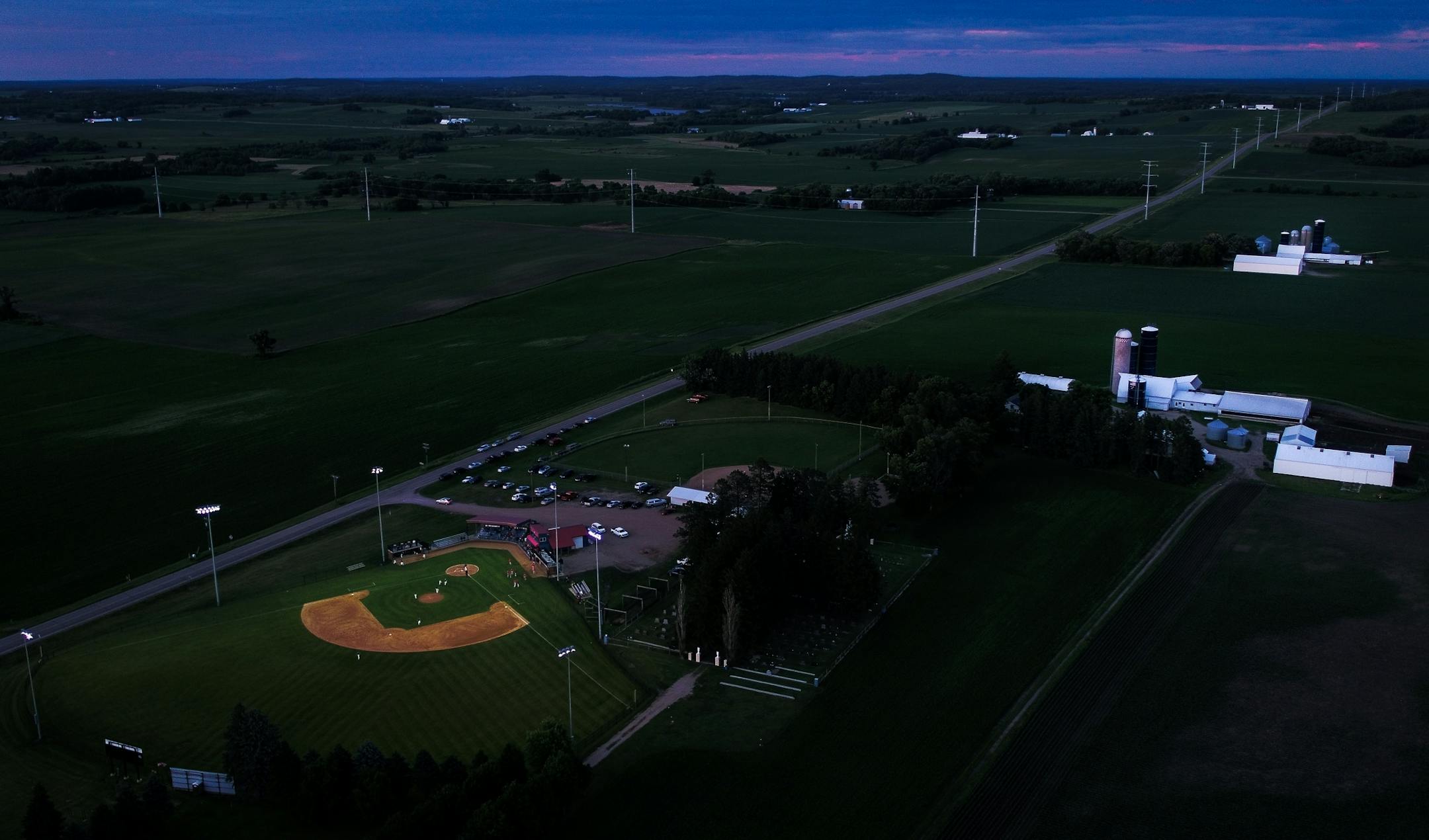 The Farming Flames Baseball Field was illuminated as the sun set on Friday, June 23, 2017 in Farming, Minn. during a tournament game between the Farming Flames and the Sartell Muskies.