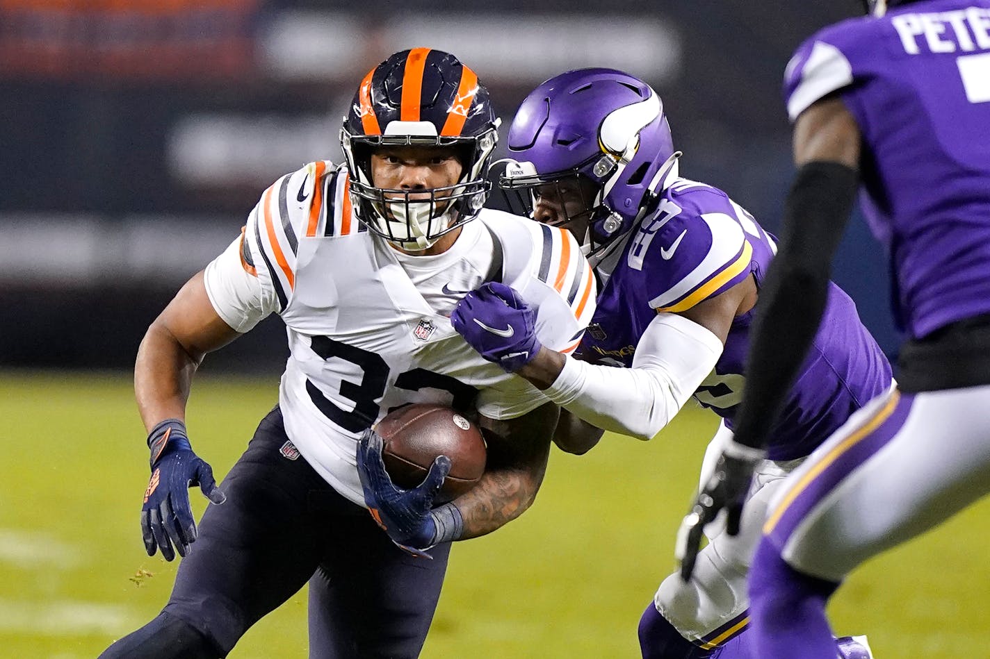 Chicago Bears running back David Montgomery carries the ball as Minnesota Vikings free safety Xavier Woods makes the tackle during the first half of an NFL football game Monday, Dec. 20, 2021, in Chicago. (AP Photo/Nam Y. Huh)