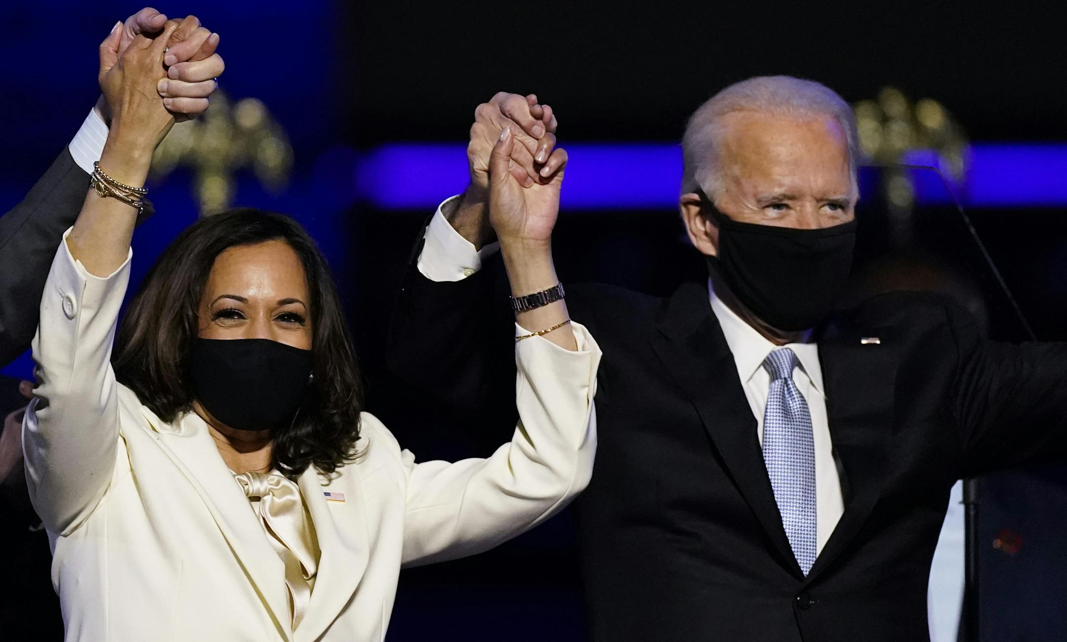 FILE - In this Nov. 7, 2020, file photo Vice President-elect Kamala Harris holds hands with President-elect Joe Biden and her husband Doug Emhoff as they celebrate in Wilmington, Del. Black policy leaders will play a pivotal role in President-elect Joe Biden's transition team, marking one of the most diverse presidential agency review teams in history. (AP Photo/Andrew Harnik, File)