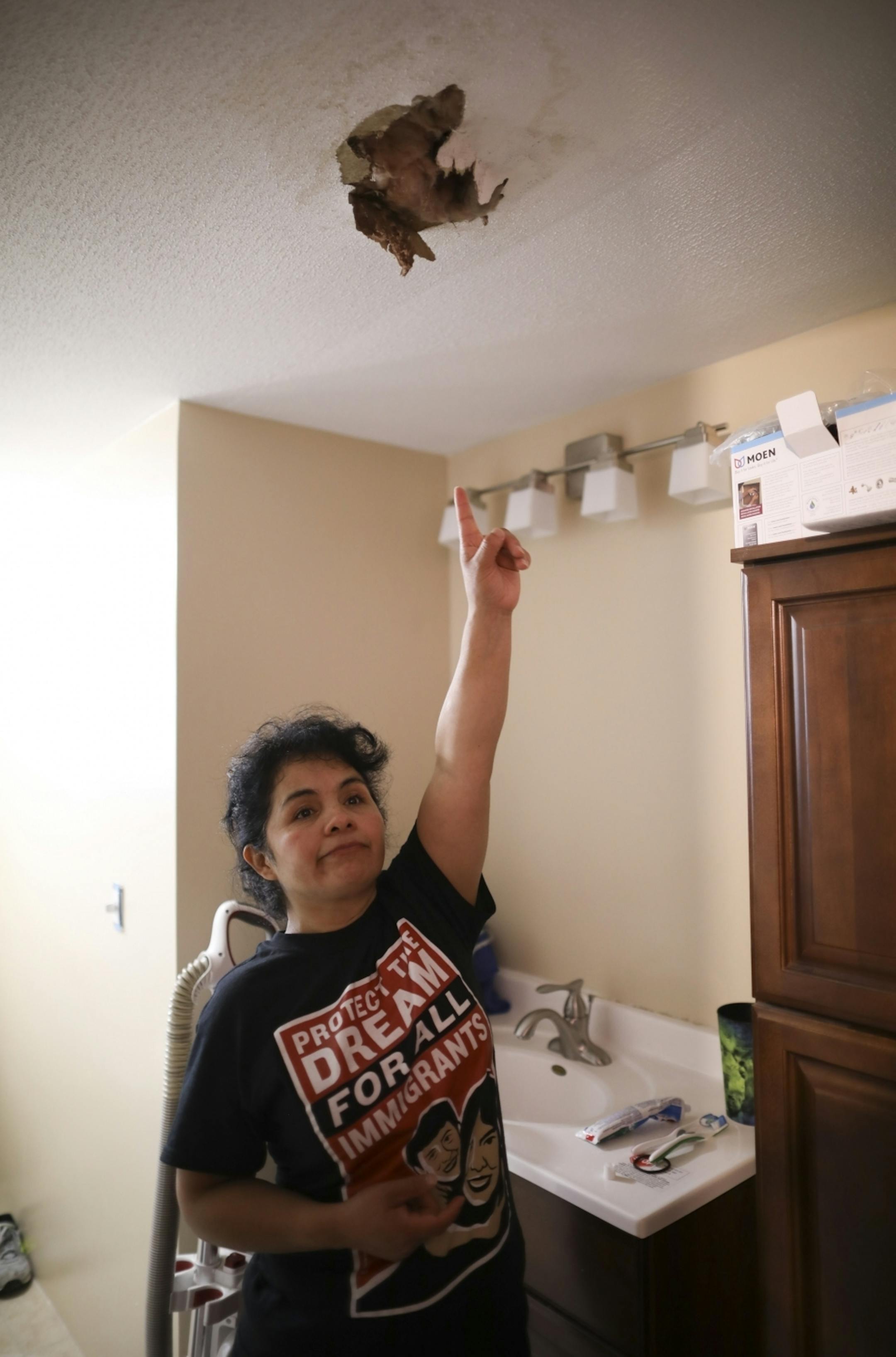 Antonia Alvarez showed a hole that needs to be repaired in the ceiling of the mobile home she is moving into at Lakeside Homes in New Brighton. The former resident of Lowry Grove mobile home park in St. Anthony is among several families who have relocated to Lakeside Homes.