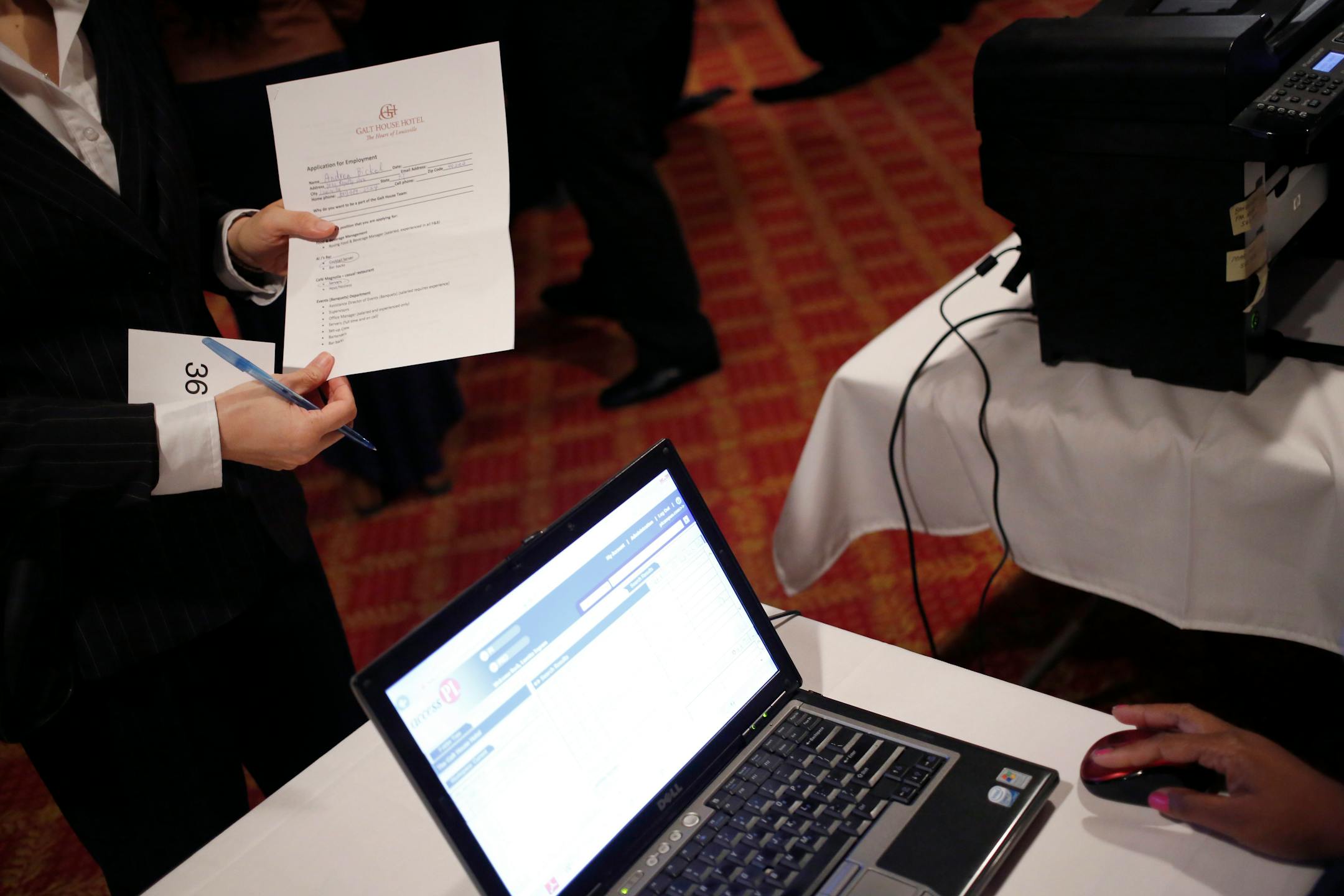 A job seeker holds an employment application during a job fair hosted by the Galt House Hotel in Louisville, Kentucky, U.S., on Monday, Oct. 14, 2013. Improvement in the U.S. labor market may soon speed up, building on gains during the past year, Federal Reserve researchers said, citing six employment indicators. Photographer: Luke Sharrett/Bloomberg