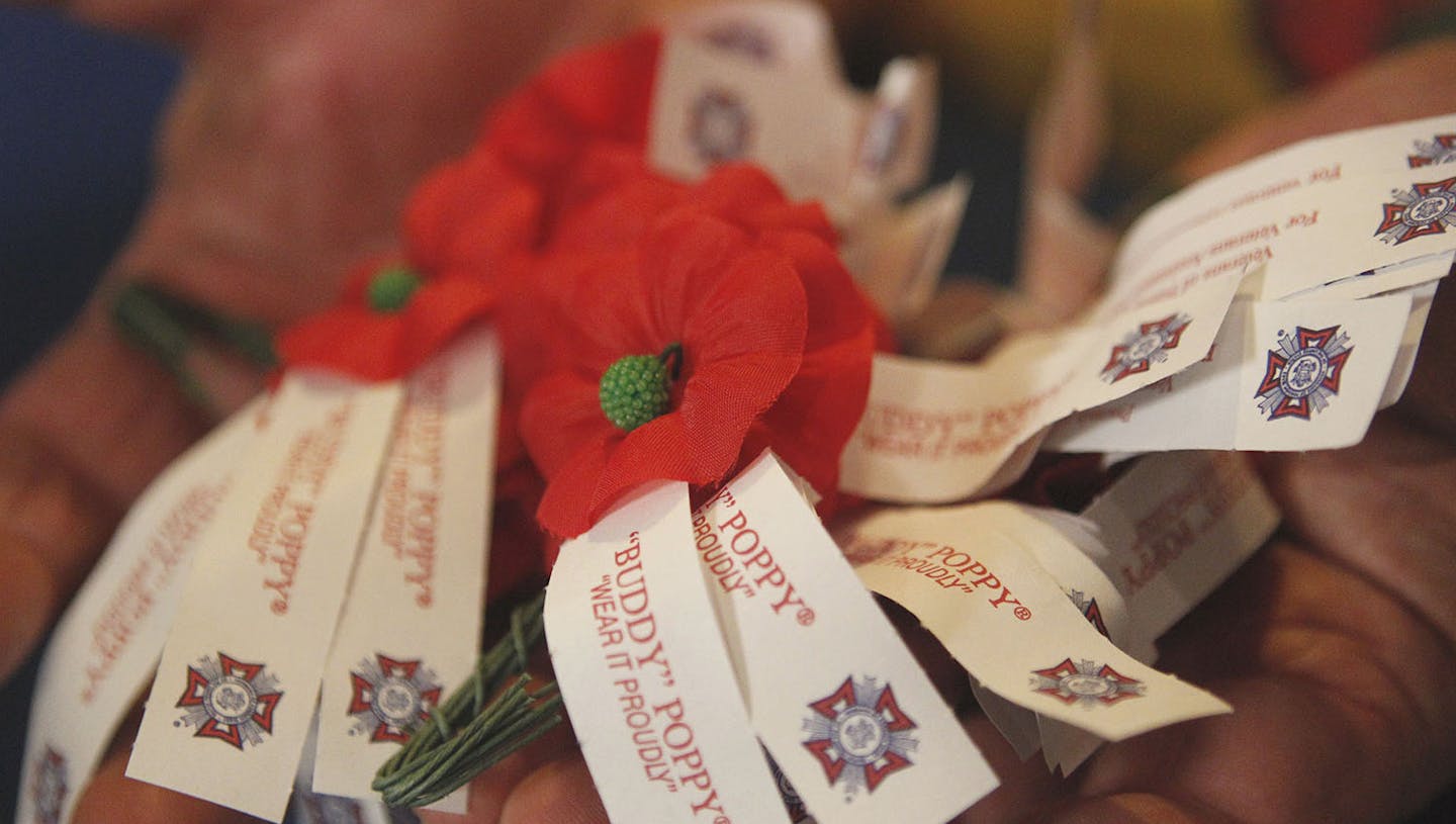 Joseph Hatfield, "Poppa Joe," holding poppies, which are the official memorial flowers of the Veterans of Foreign Wars of the United States, for the VFW "Buddy" poppy distribution before Memorial Day, at the Piney Green VFW in Jacksonville Friday, May 23, 2014. (AP Photo/The Jacksonville Daily News, Maria Sestito) ORG XMIT: NCJAC104