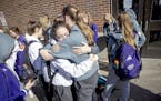 Members of the Rochester Lourdes girls' basketball team including, Marissa Houfek, left, and Ella Hopkins, hugged each other after they left Williams 