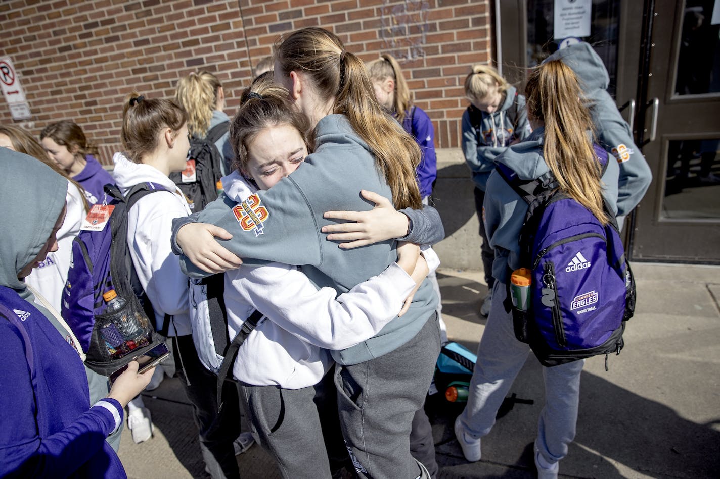 Members of the Rochester Lourdes girls' basketball team including, Marissa Houfek, left, and Ella Hopkins, hugged each other after they left Williams Arena. The MSHSL announced the cancellation of the tournament and next week's boys' tournament.