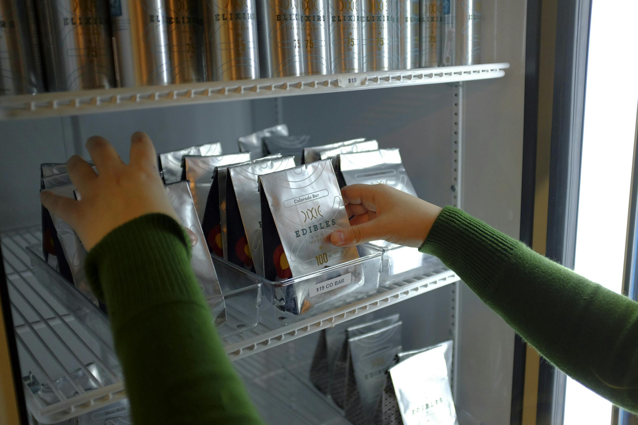 FILE-- Haley Andrews restocks shelves with packages of marijuana-infused candies for sale at the LoDo Wellness Center in Denver, Jan. 29, 2014. After fives months of retail sales, adult deaths and children‚Äôs emergency room visits in Colorado are being linked to newly legal marijuana, often in its edible form, and opponents of legalization are warning other states to pay heed. (Matthew Staver/The New York Times)