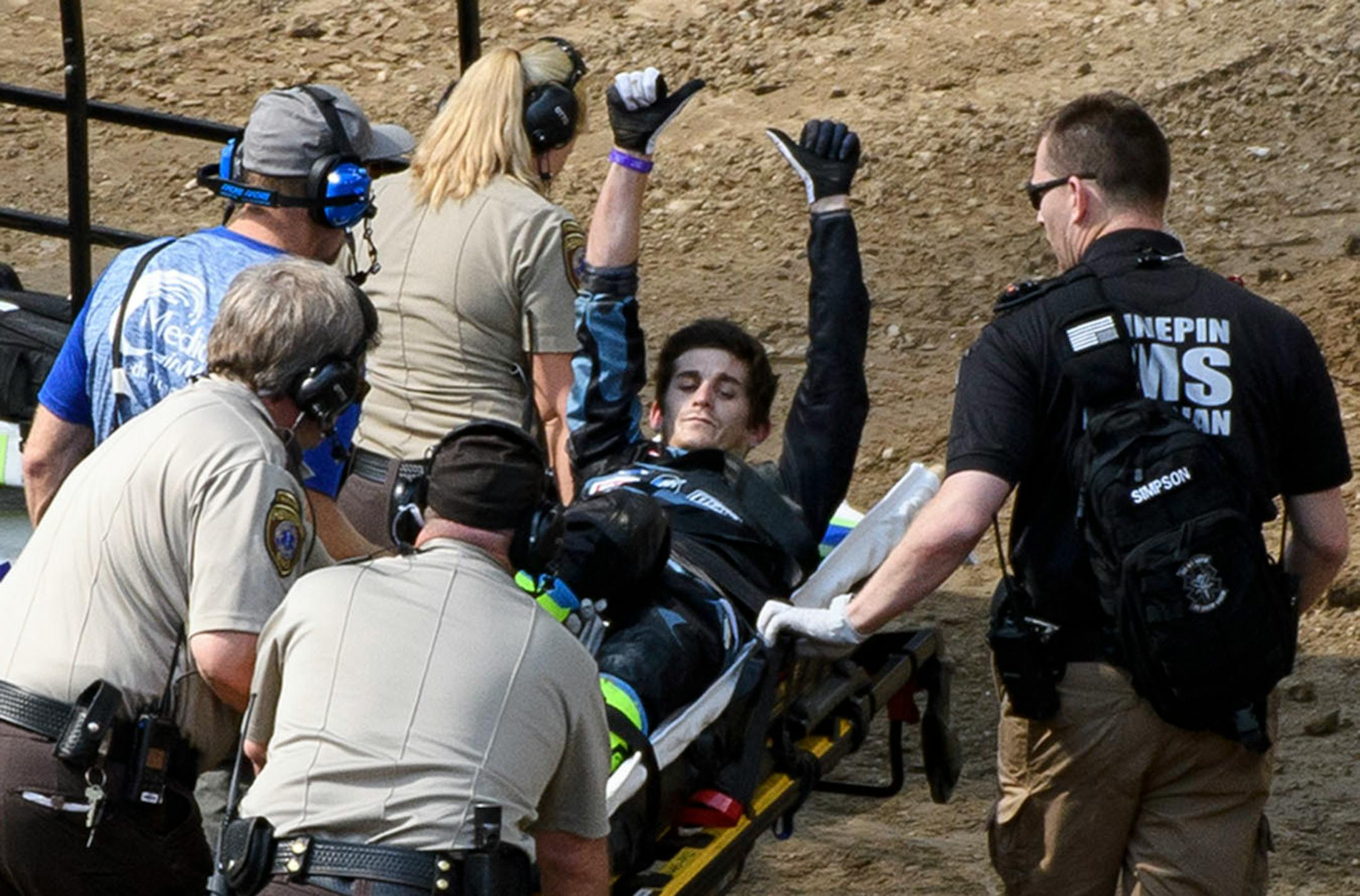 Jarryd McNeil gestured to fans as he was carted off the dirt after a bad fall in the motocross quarter pipe high air final.