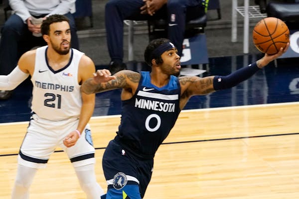Tyus Jones ooks on as the Timberwolves' D'Angelo Russell lays up a shot in the second half