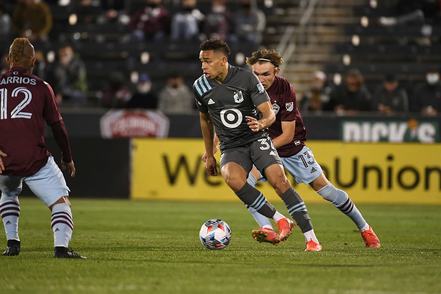 Minnesota United midfielder Hassani Dotson, front, moves the ball past Colorado Rapids defender Sam Vines during an MLS soccer match Saturday, May 8, 2021, in Commerce City, Colo. (AP Photo/Bart Young)