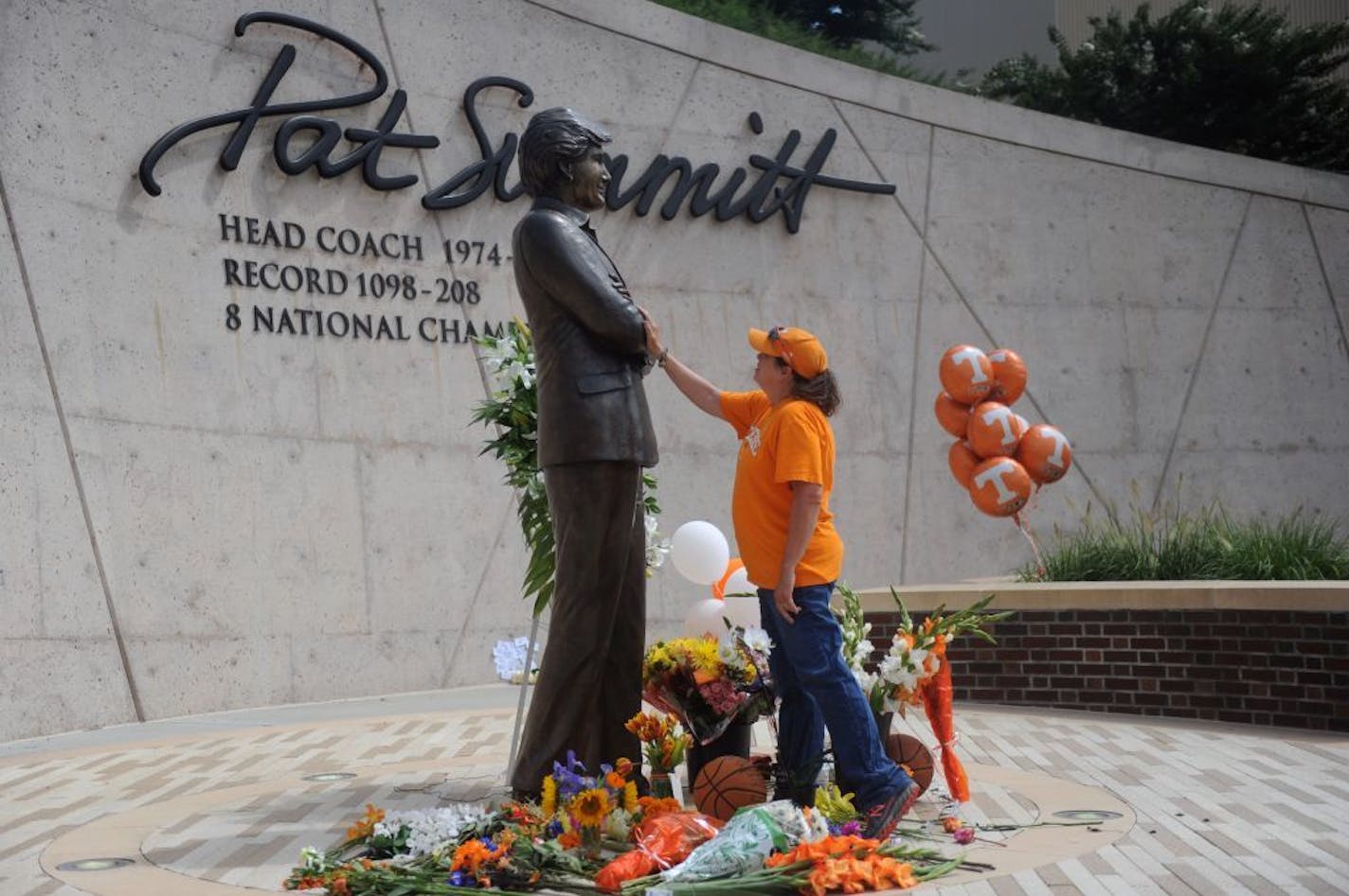 Teresa Olive, of Knoxville, Tenn., touches a statue of Pat Summitt as she pays her respects at the University of Tennessee, on Tuesday, June 28, 2016, in Knoxville, Tenn. Summitt, the winningest coach in Division I college basketball history who uplifted the women's game from obscurity to national prominence during her career at Tennessee, died Tuesday morning, June 28, 2016. She was 64. (Caithe McMekin/Knoxville News Sentinel via AP) MANDATORY CREDIT