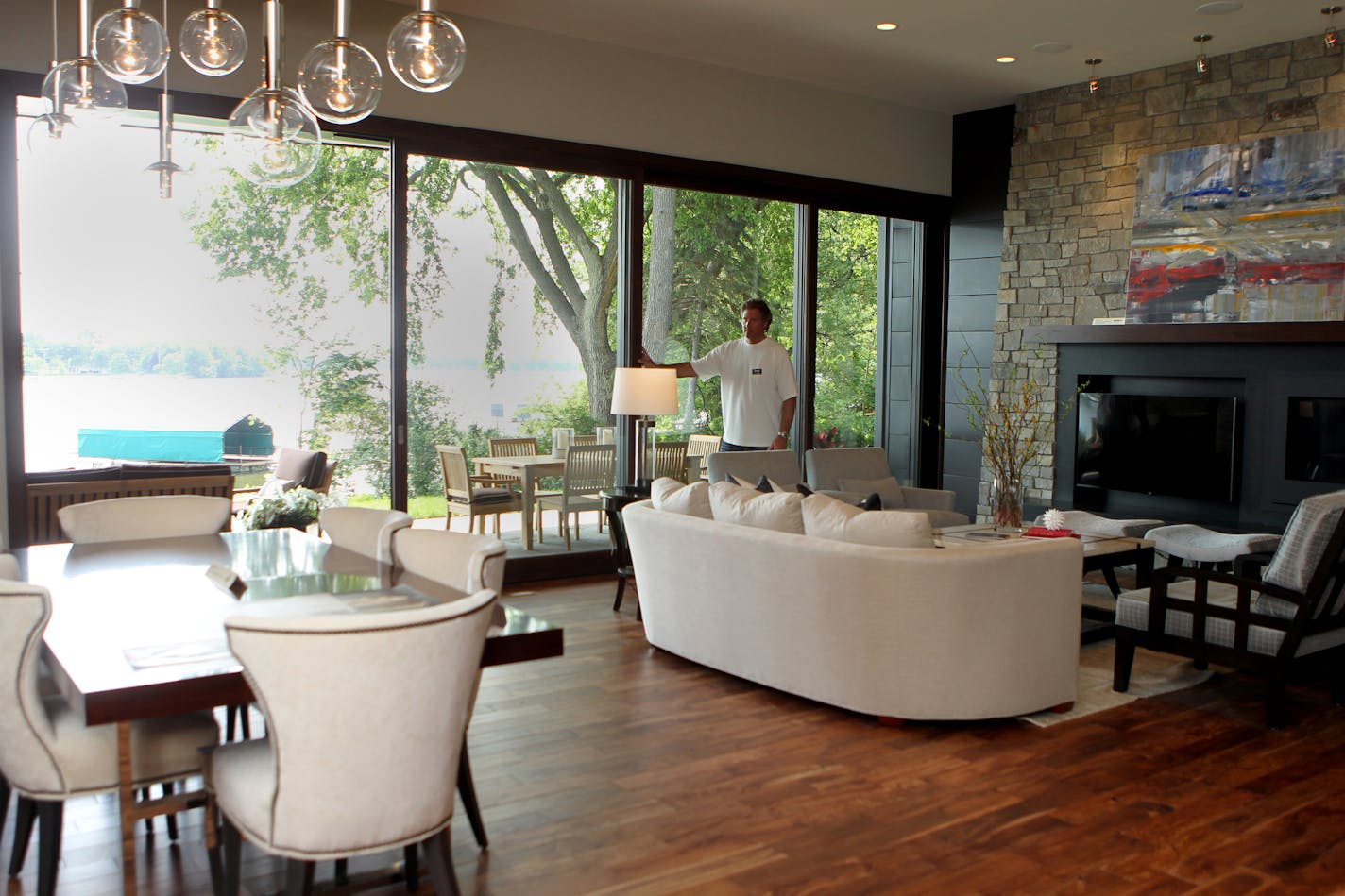 Custom home builder David Bieker closes the sliding glass doors leading to the patio overseeing Lake Minnetonka that are a main feature in a custom built home in Greenwood, Minn., on Friday, June 20, 2013. ] (ANNA REED/STAR TRIBUNE) anna.reed@startribune.com (cq)