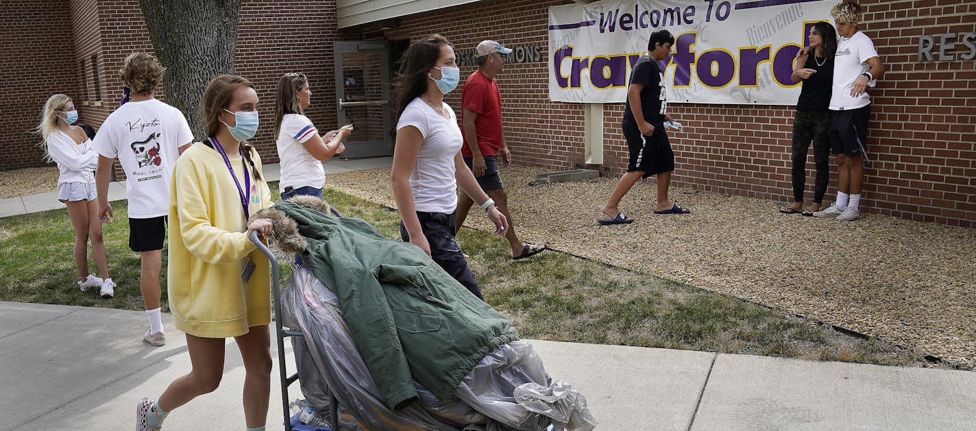 Students began moving into dormitories at Minnesota State University-Mankato Thursday where freshman Marissa Ellenbecker of Edgar, WI, front left, and friend Makenna Guden, moved Ellenbecker's belongings into her Crawford Residence as fellow freshman Gavin Roy, rear right, posed for photos with family members.] DAVID JOLES • david.joles@startribune.com Minnesota colleges are taking different approaches to COVID-19 testing and monitoring of students this fall, with some schools taking more precau