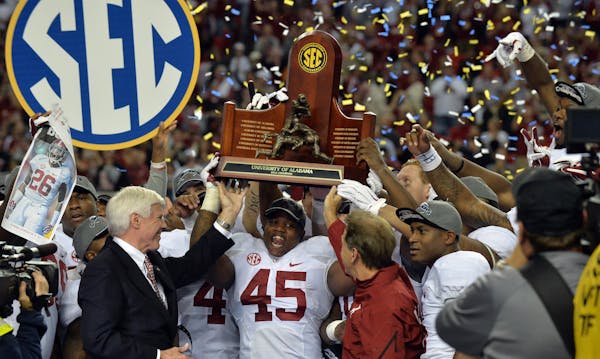Alabama Crimson Tide running back Jalston Fowler holds the SEC Championship trophy after defeating Missouri Saturday, Dec. 6, 2014 at the Georgia Dome
