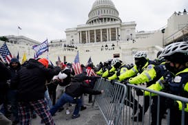 FILE - Insurrectionists loyal to President Donald Trump try to break through a police barrier, Wednesday, Jan. 6, 2021, at the Capitol in Washington. 