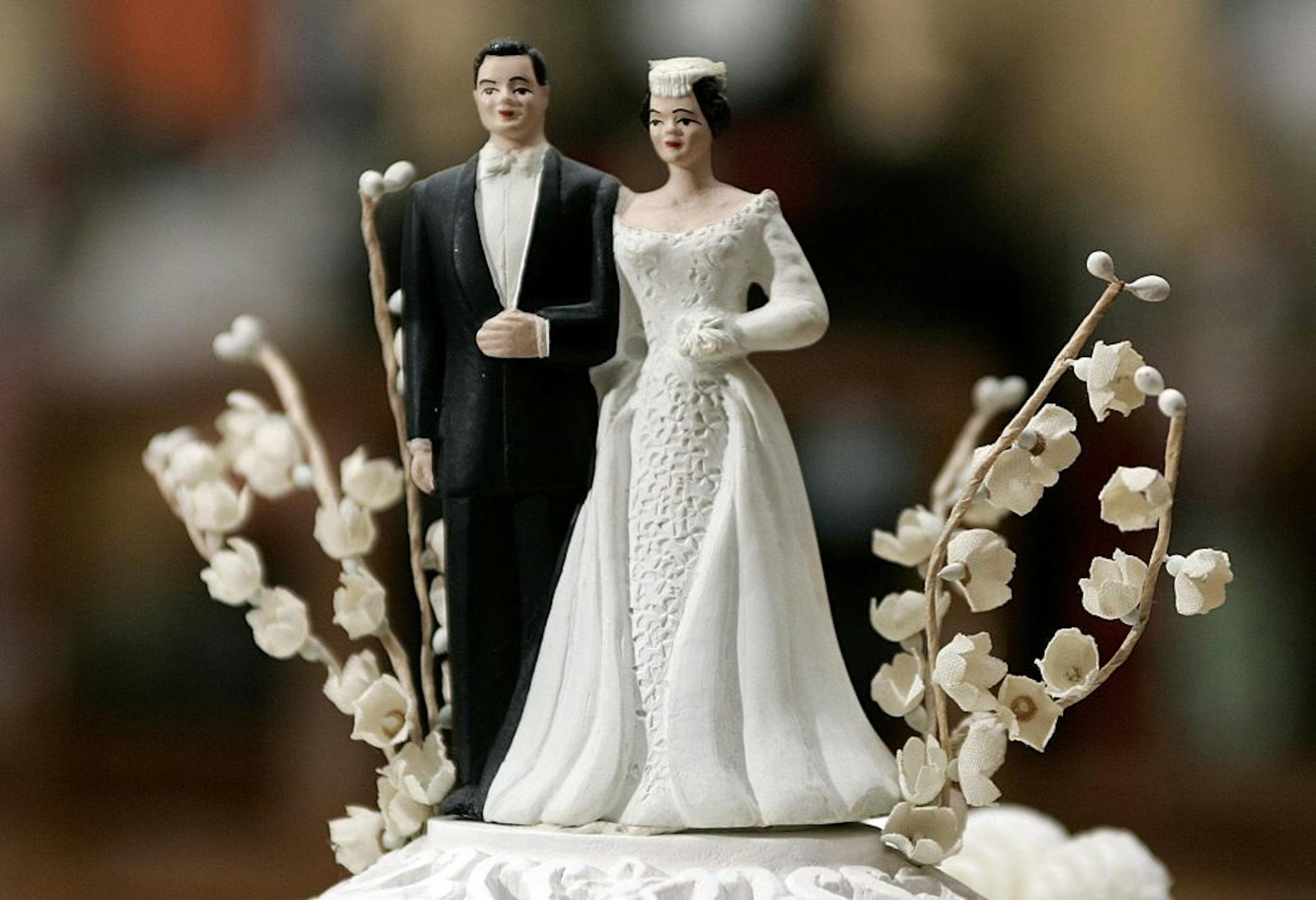 Bride and groom figurines on top of a wedding cake.