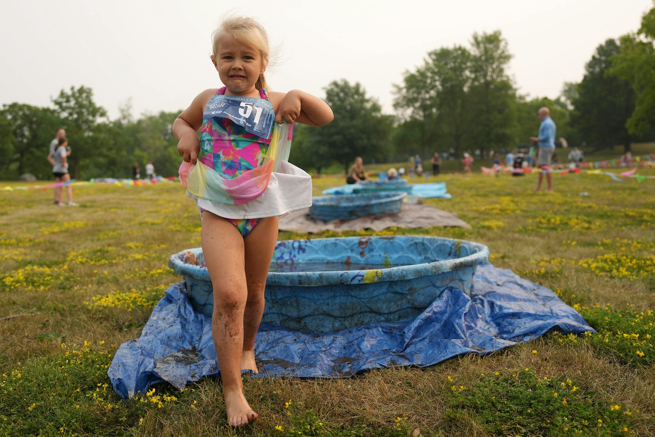 Evercyn Dawson, 4, of Chaska reacts skeptically as she passes through the last of the mud pits during the Minneswashta Mud Run's Mini Mud Run.