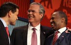 Republican presidential candidates from left, Marco Rubio, Jeb Bush and Ben Carson talk during a break during the first Republican presidential debate
