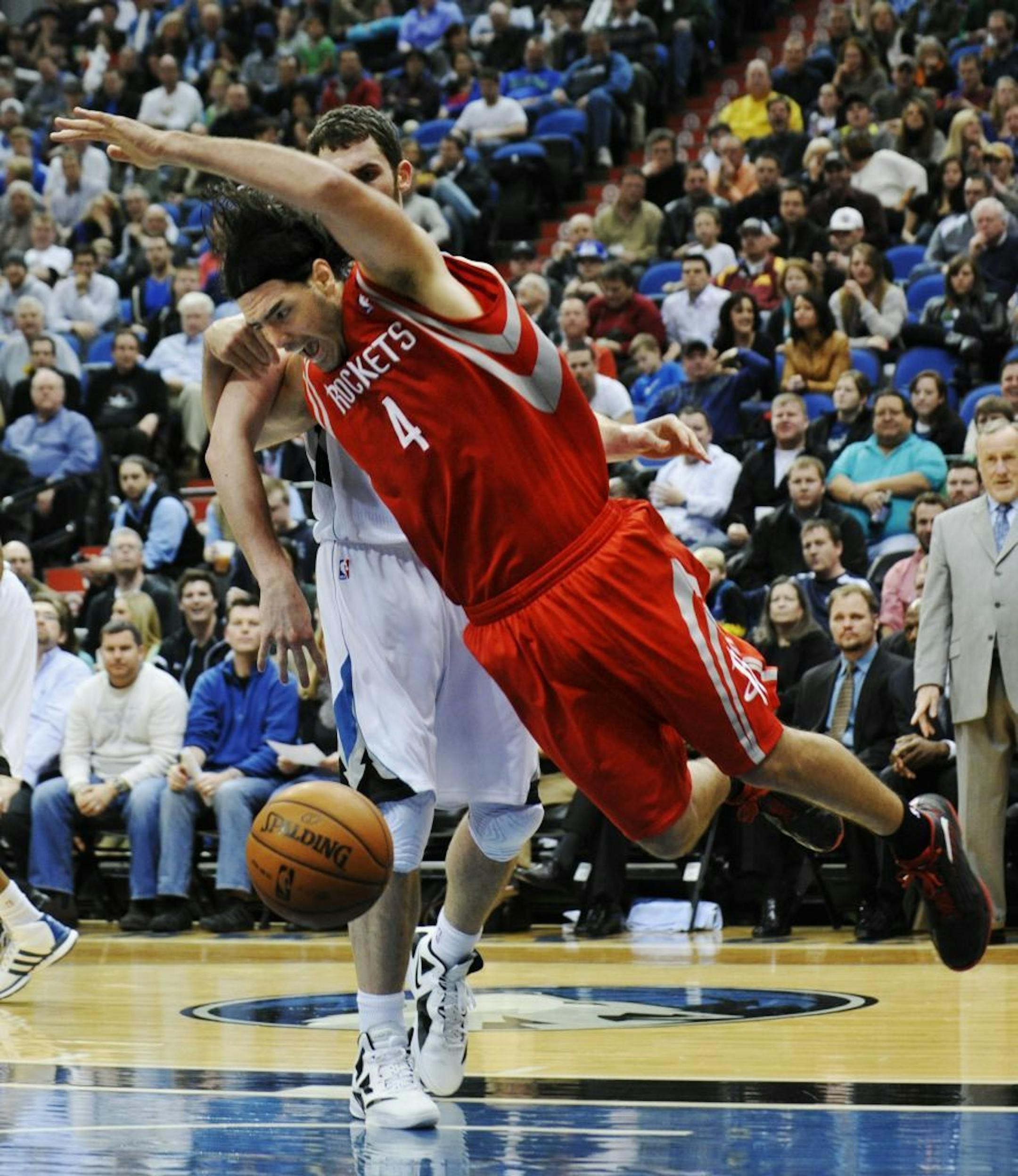 Houston Rockets' Luis Scola, of Argentina, is knocked to the floor by Minnesota Timberwolves' Kevin Love, rear, in the second half of an NBA basketball game Saturday, Feb. 4, 2012, in Minneapolis. No penalty was called on the play. The Timberwolves won 100-91.