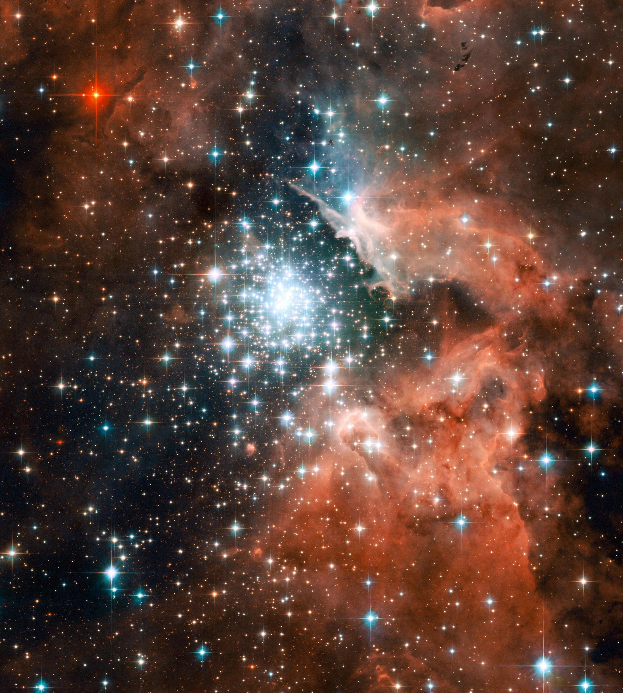 Thousands of sparkling young stars nestled within the giant nebula NGC 3603. This stellar "jewel box" is one of the most massive young star clusters in the Milky Way Galaxy. NGC 3603 is a prominent star-forming region in the Carina spiral arm of the Milky Way, about 20,000 light-years away. This image shows a young star cluster surrounded by a vast region of dust and gas. The image reveals stages in the life cycle of stars. The nebula was first discovered by Sir John Herschel in 1834. The image