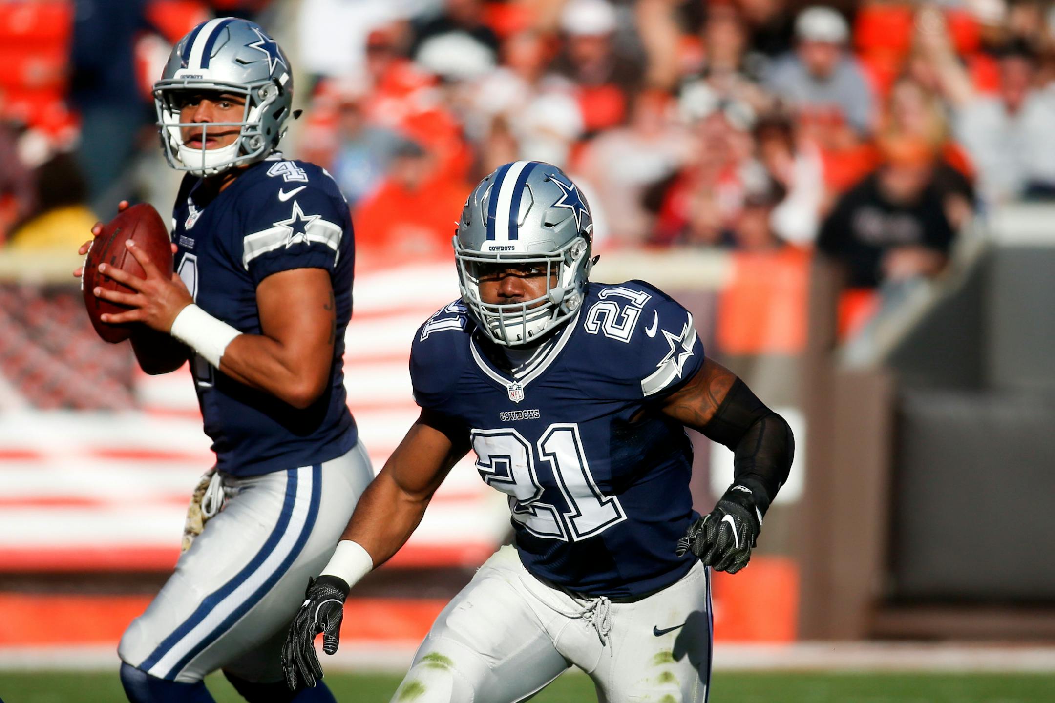 Dallas Cowboys running back Ezekiel Elliott (21) runs on a play as quarterback Dak Prescott (4) looks to pass in the second half of an NFL football game against the Cleveland Browns, Sunday, Nov. 6, 2016, in Cleveland. (AP Photo/Ron Schwane)