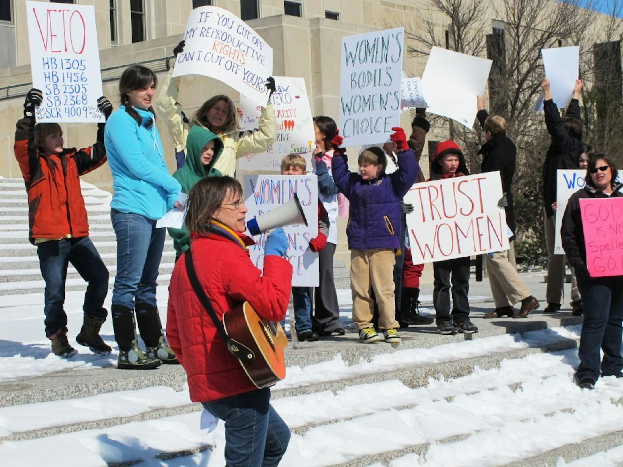 FILE - In this March 25, 2013, file photo Kris Kitko, left, leads chants of protest at an abortion-rights rally at the state Capitol in Bismarck, N.D. Abortion-rights advocates filed a lawsuit in federal court Tuesday, June 25, 2013, in Bismarck, N.D., challenging two new North Dakota laws that impose the nation's toughest abortion restrictions.