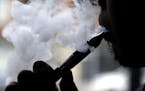 FILE - In this April 23, 2014 file photo, a man smokes an electronic cigarette in Chicago. A large government survey released Thursday, June 15, 2017,
