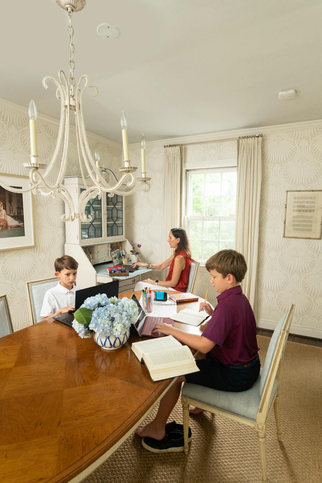 Interior designer Marika Meyer (with sons Grayson, 11, and Colin, 8) has turned her old dining room into a family game room and now utilizes a larger space as her family’s mixed-use dining area.