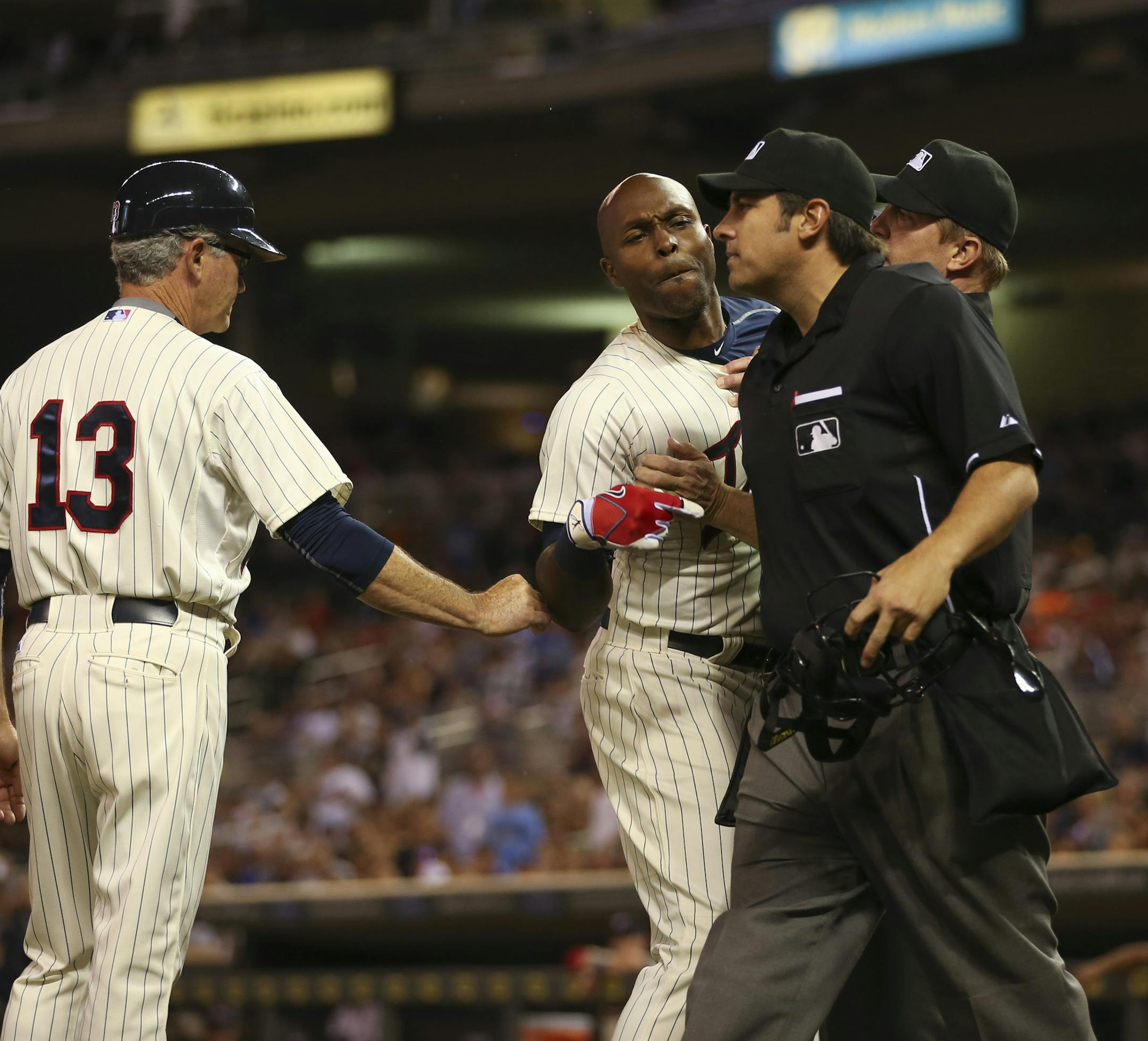 First base umpire Jeff Kellogg, obscured, restrained the Twins' Torii Hunter as he yelled at home plate umpire Mark Ripperger, right, after her ejected Hunter for arguing a called third strike in the eighth inning Wednesday night at Target Field. Twins manager Paul Molitor was also ejected after he came to Hunter's defense. ] JEFF WHEELER ï jeff.wheeler@startribune.com The Minnesota Twins lost 7-2 to the Kansas City Royals Wednesday night, June 10, 2015 at Target Field in Minneapolis.
