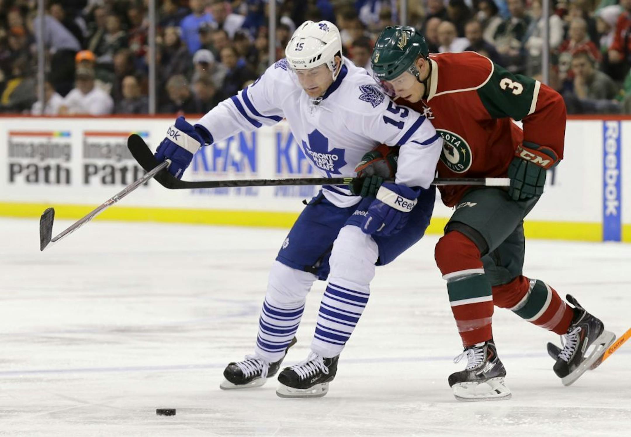 Toronto Maple Leafs defenseman Paul Ranger (15) and Minnesota Wild center Charlie Coyle (3) skate for the puck during the second period of an NHL hockey game in St. Paul, Minn., Wednesday, Nov. 13, 2013.