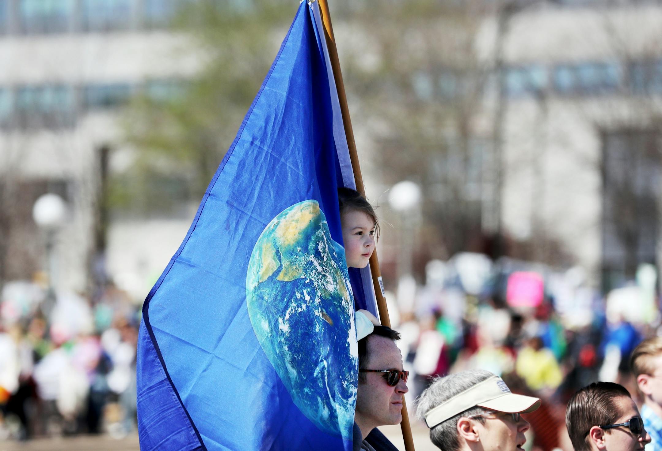 March for Science moved from the start at Cathedral Hill Park to State Capitol, with an estimated 10,000 or more joining to champion the role of science in American life. Here, a girl and her father are enveloped in an earth flag during the March for Science near the State Capitol Mall Saturday, April 22, 2017, in St. Paul, MN.