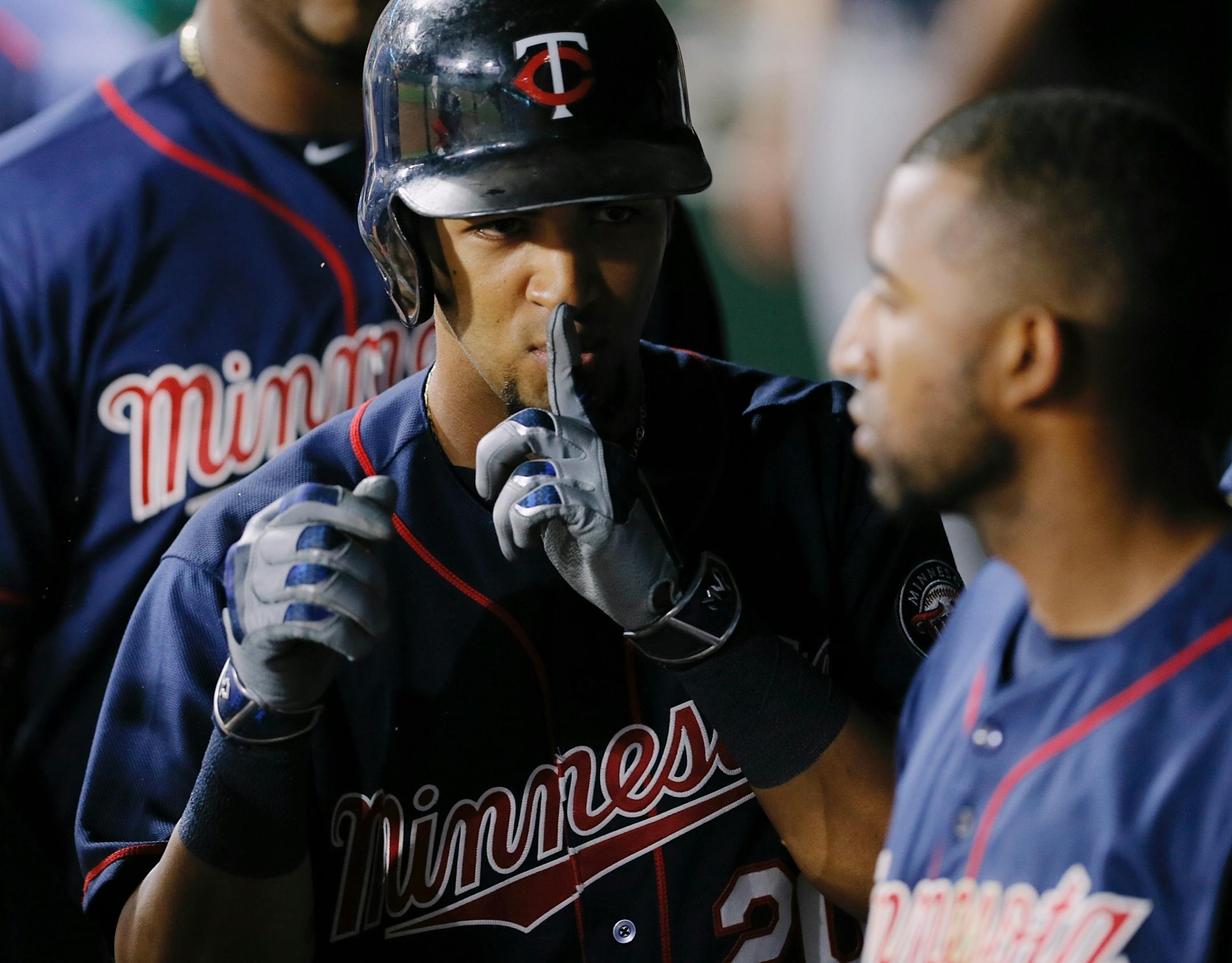 Minnesota Twins' Eddie Rosario, center, gestures in the dugout after hitting a solo home run during the fifth inning of a baseball game against the Texas Rangers on Saturday, July 9, 2016, in Arlington, Texas. (AP Photo/Brandon Wade)