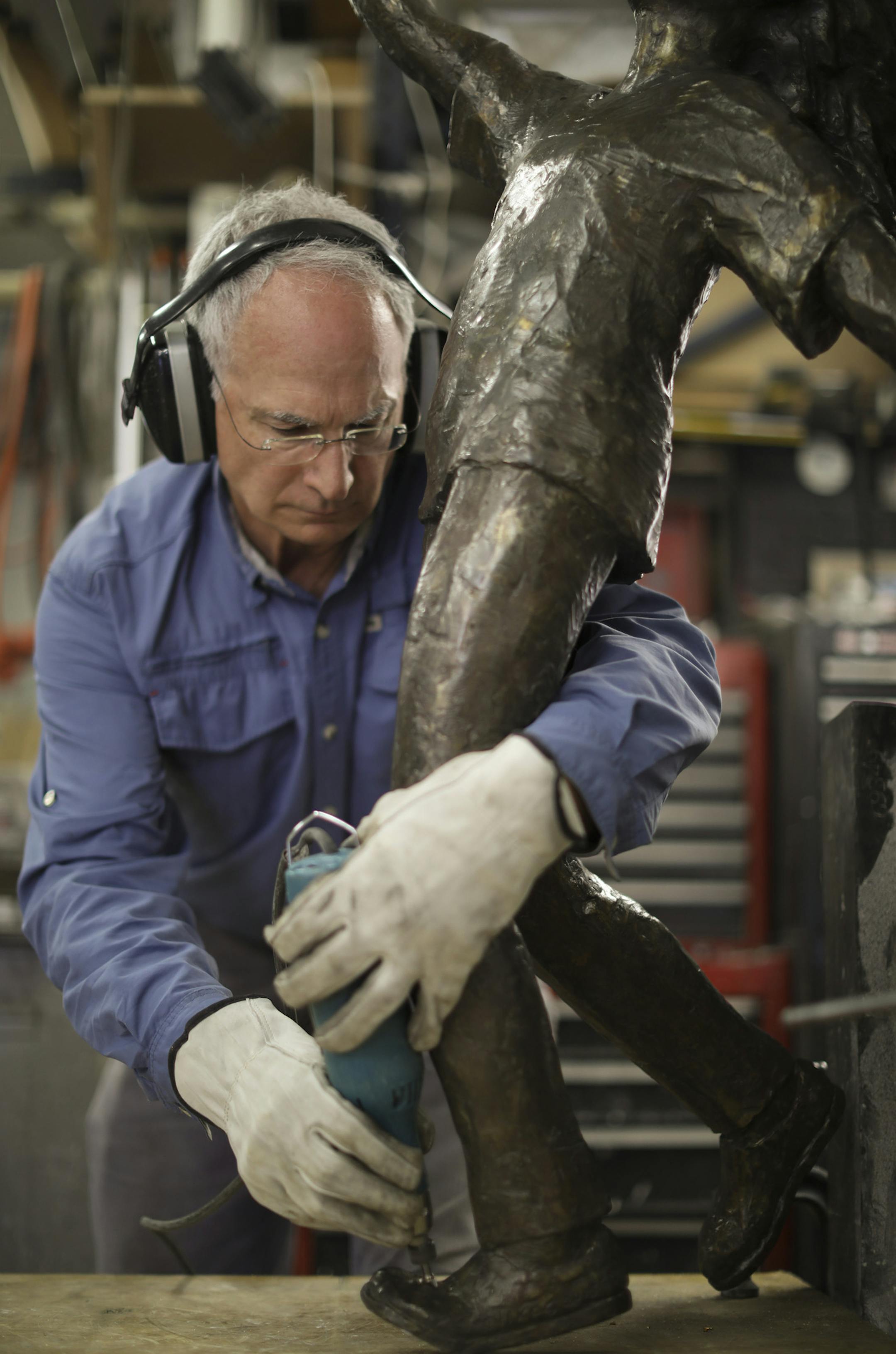 Nick Legeros ground away material from the foot of his piece "Dreams Take Flight" before fabricating a new anchor point for the sculpture. ] JEFF WHEELER ï jeff.wheeler@startribune.com The bronze statue that was stolen from a park in Edina was found in a yard in neighboring Richfield. It has been returned to the artist who made it, Nick Legeros, who will prepare it in his Northeast studio for reinstallation as early as next week. Nick Legeros with his sculpture, "Dreams Take Flight," in his