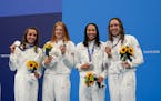 The United States' women's 4x100-meter medley relay team, Regan Smith, Lydia Jacoby, Torri Huske and Abbey Weitzeil, celebrates at the podium after wi