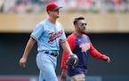 Minnesota Twins starting pitcher Tyler Mahle, left, exits the game with head athletic trainer Michael Salazar during the third inning of a baseball ga