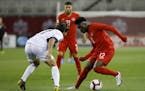 Canada midfielder Alphonso Davies (12) dribbles against Cuba defender Jean Carlos Rodriguez (17) during the first half of a CONCACAF Nations League so