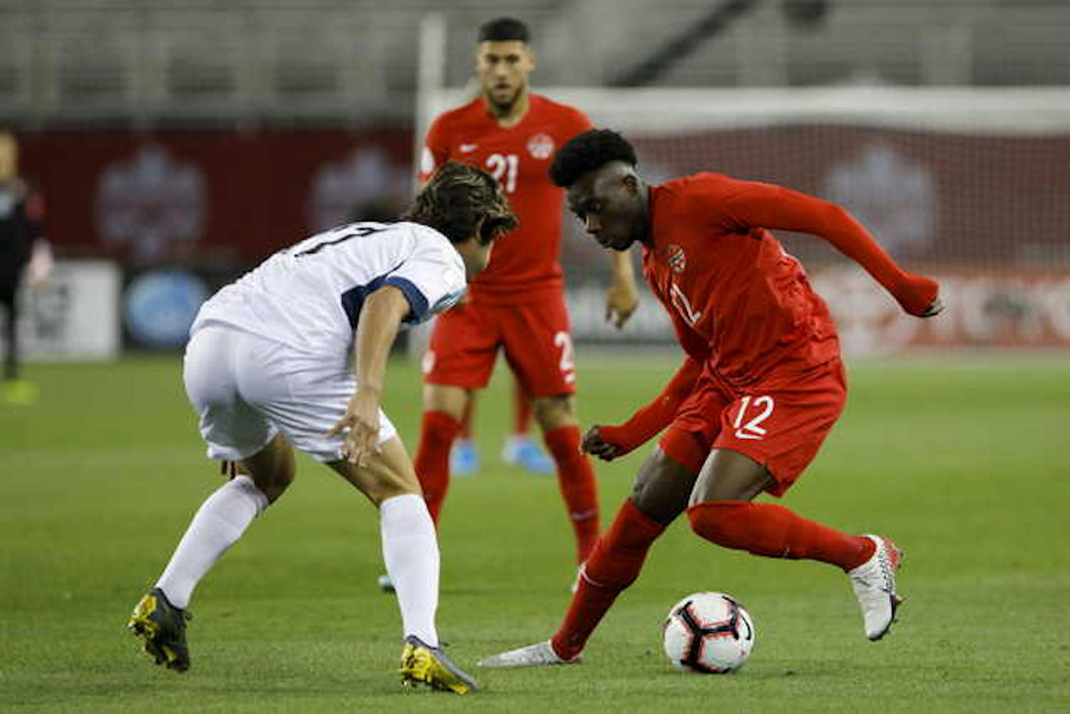 Canada midfielder Alphonso Davies (12) dribbles against Cuba defender Jean Carlos Rodriguez (17) during the first half of a CONCACAF Nations League soccer match in Toronto on Sept. 7.