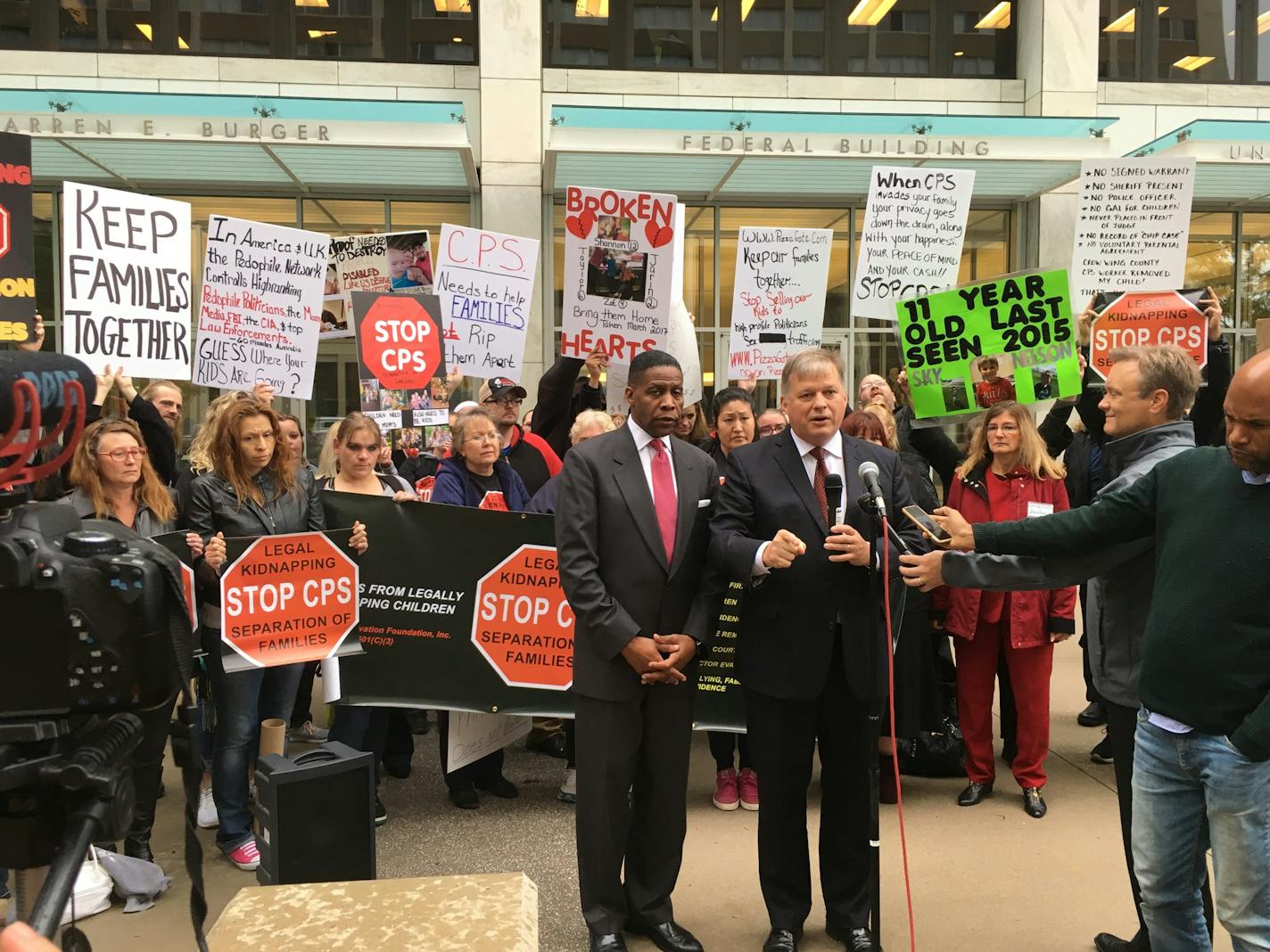 Dwight Mitchell, left, and his attorney, Erick Kaardal, right, call for changes to the state's child-protection system outside the federal courthouse in St. Paul.