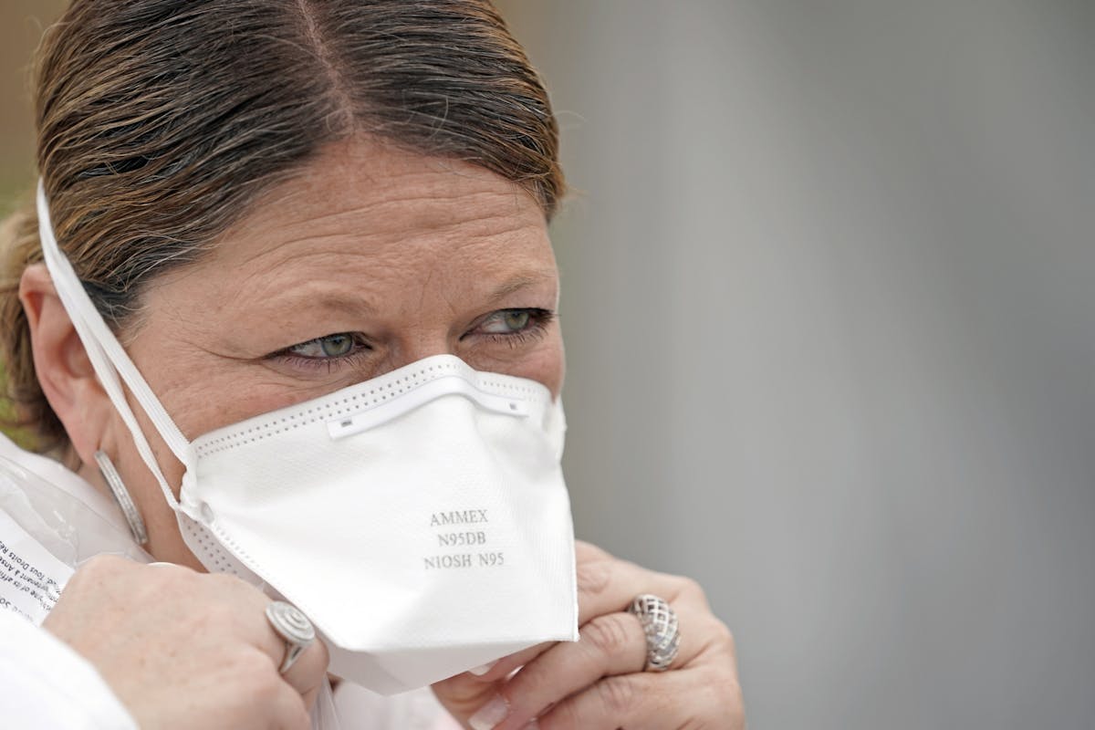 A nurse adjusted her N95 mask at a free testing site in Houston. Tight-fitting N95 masks are in such demand that hospitals are doing everything they c