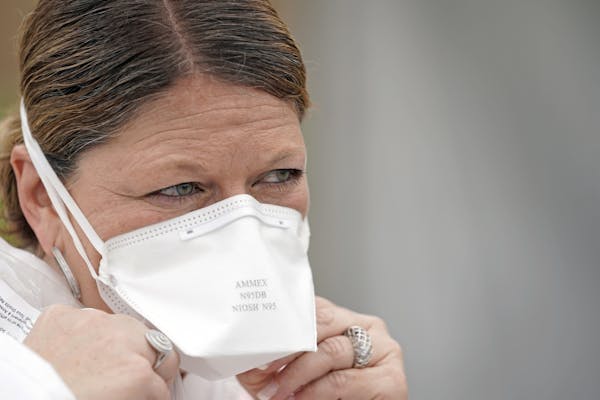 A nurse adjusted her N95 mask at a free testing site in Houston. Tight-fitting N95 masks are in such demand that hospitals are doing everything they c