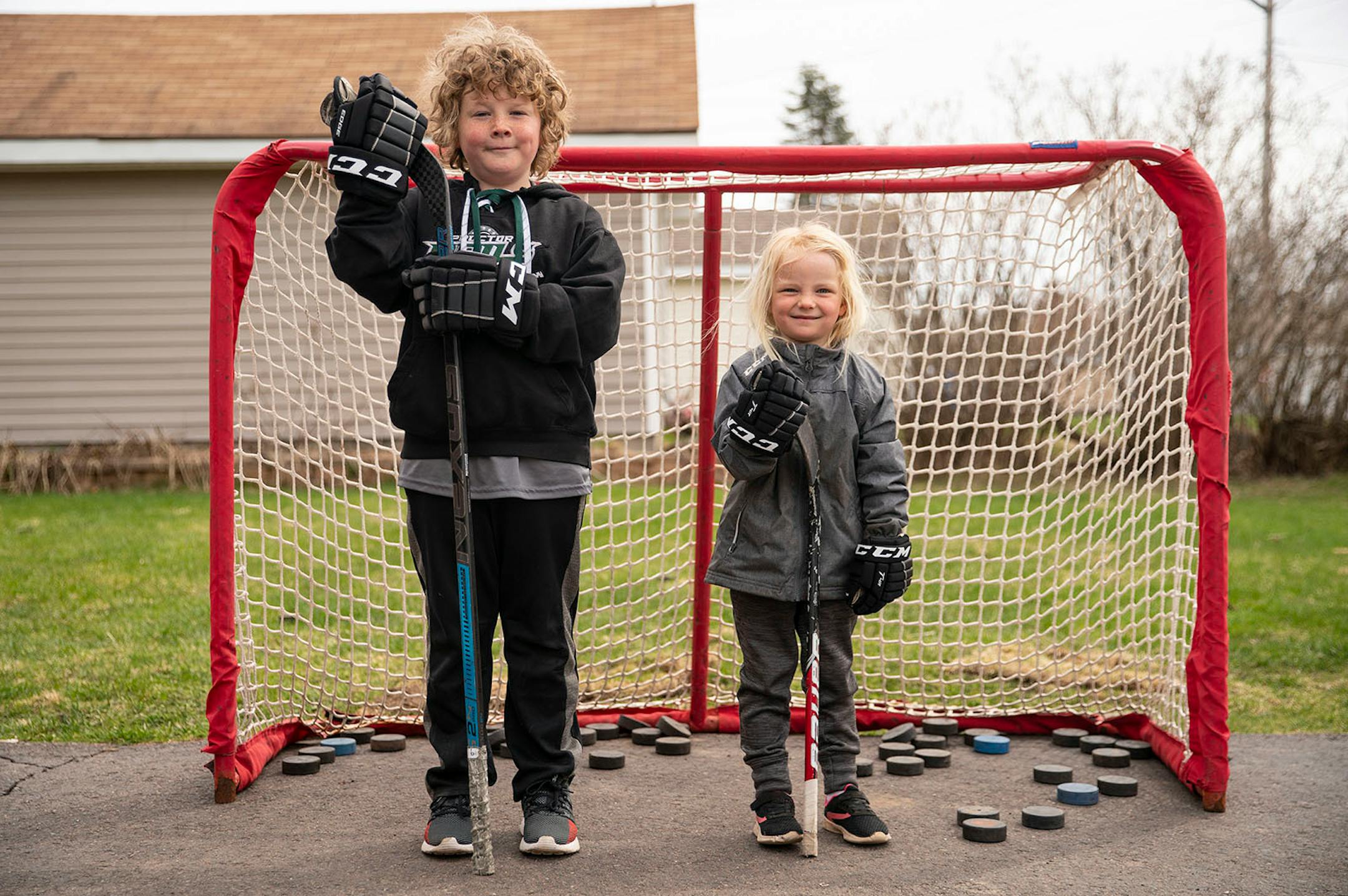 Joe Fahlin, 9, and his sister, Anna, 4, posed for a portrait in front of their family's hockey net in Cloquet. Both Joe and Anna love hockey and spend much of their quarantine time shooting into the net. The virus makes Joe feel "kinda scared and sad at the same time". But when he feels that way he is able to find happiness through hockey. "I just come out here and shoot a ton of pucks [...] because I get to be alone with my thoughts and that just makes me kind of happy," Joe said.