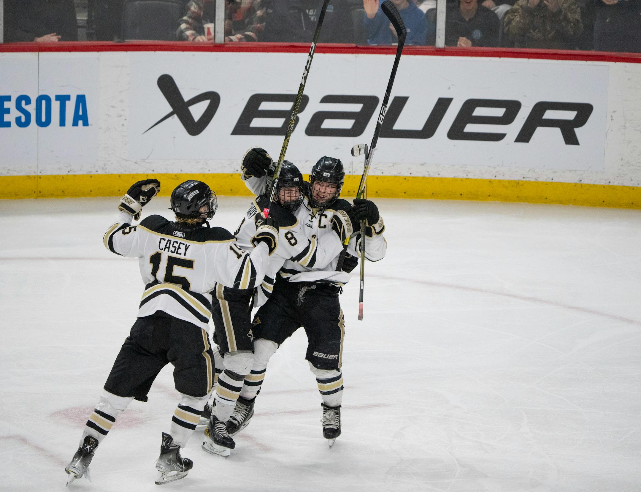 Andover Huskies forward Gavyn Thoreson (12) was congratulated by forwards Cooper Conway (8) and Cayden Casey (15) after his goal in the second period.