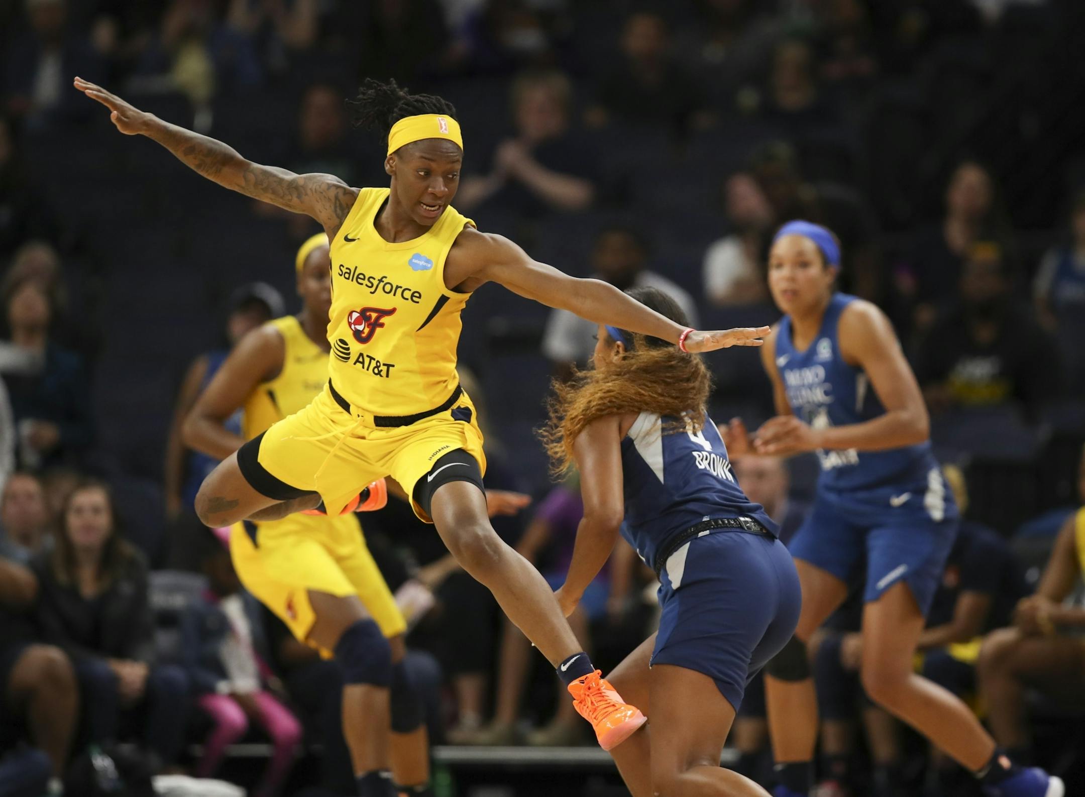 Indiana Fever guard Erica Wheeler (17) leapt past Minnesota Lynx guard Lexie Brown (4) trying to dedfend her in the fourth quarter.