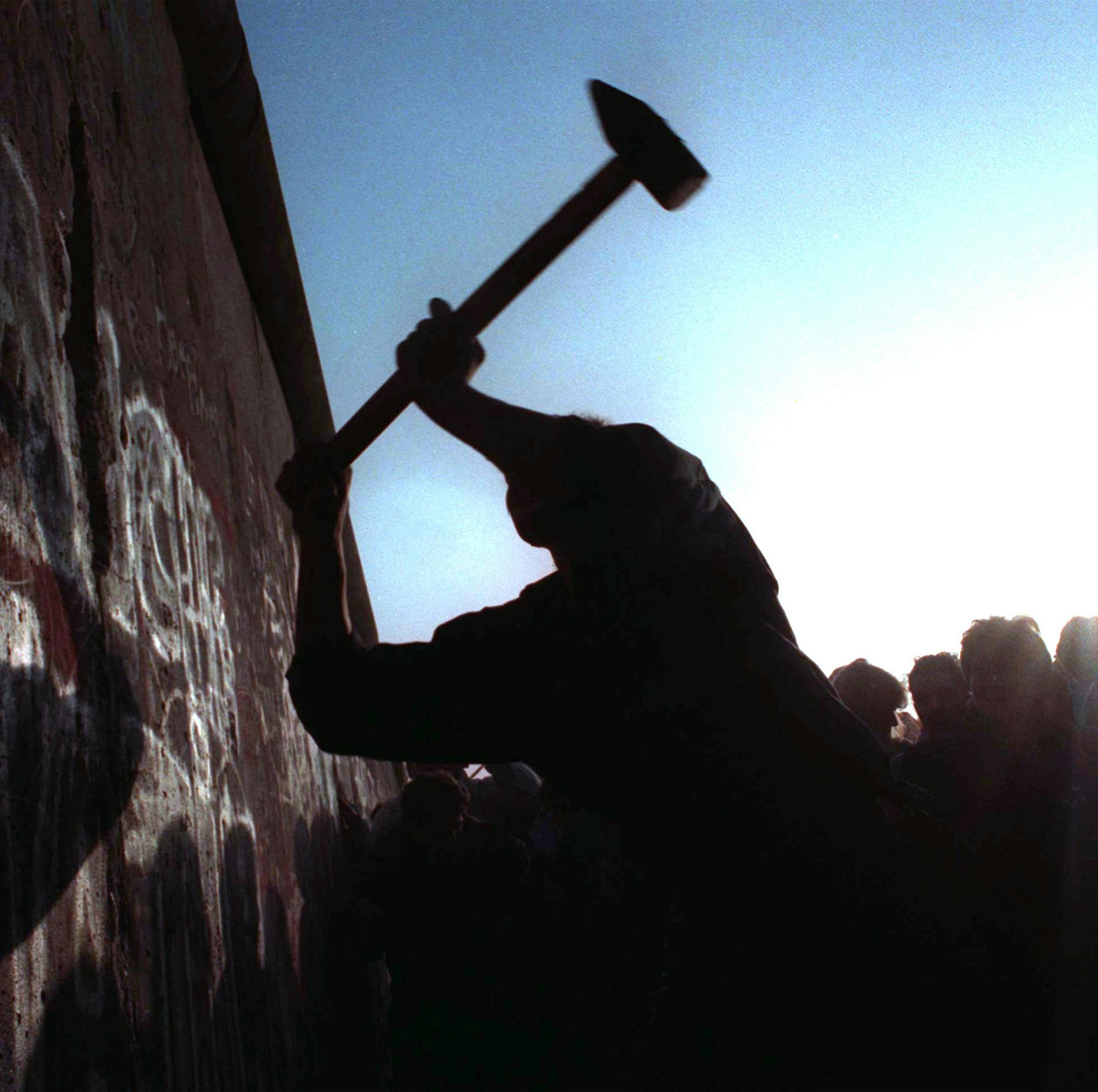 FILE - This Nov. 12, 1989 file photo shows a man hammering at the Berlin Wall, as the border barrier between East and West Germany was torn down after 28 years. Monday, Nov. 9, 2009 marks the 20th anniversary of the fall of the Berlin Wall. (AP Photo/John Gaps III, File)