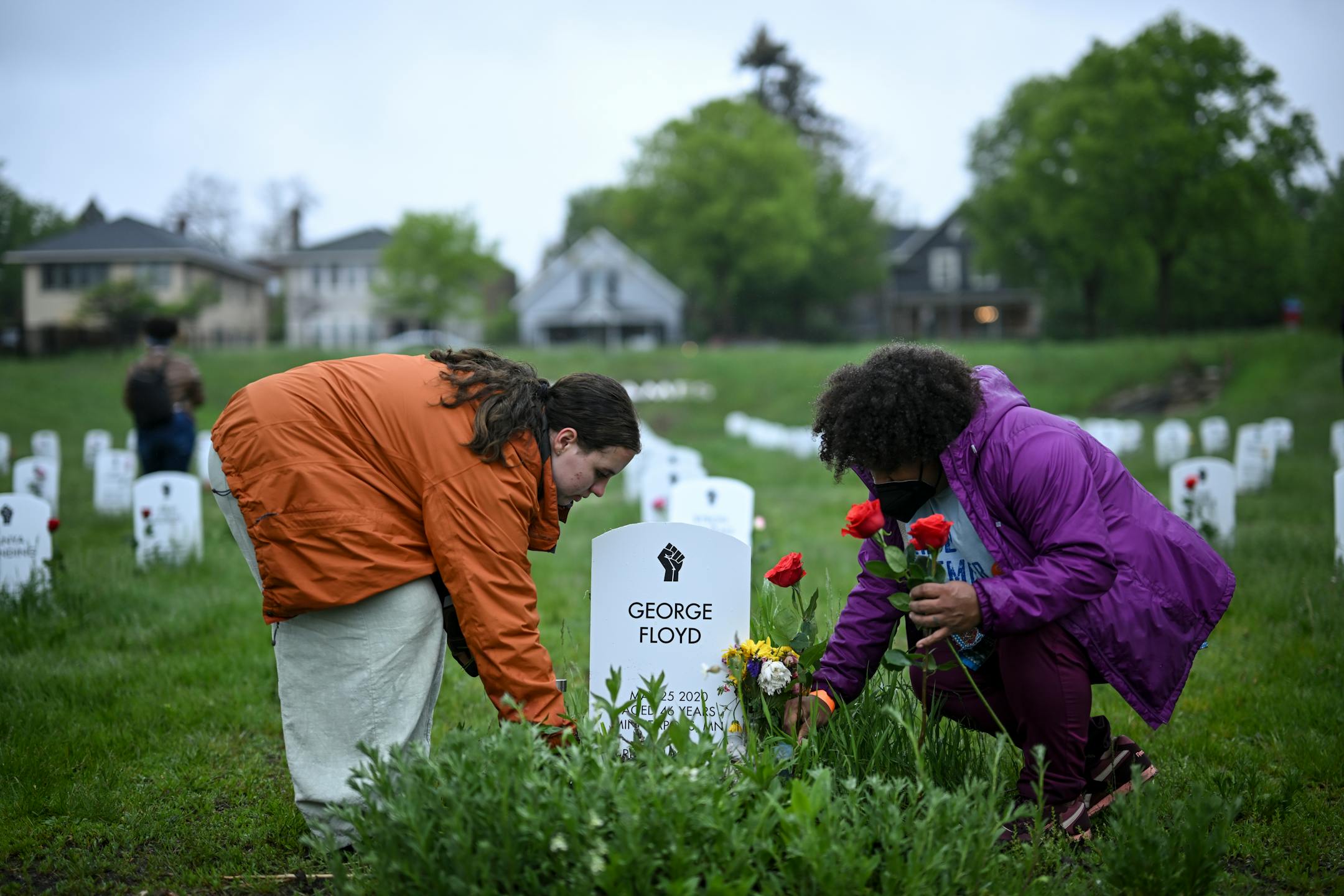 Maude McQuarrie, left, and Amber Martin lay flowers by George Floyd's gravestone at the '"Say Their Names" cemetery.
